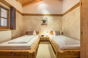 two twin beds in a room with wooden floors at Ferienwohnung Stod´l in Freyung