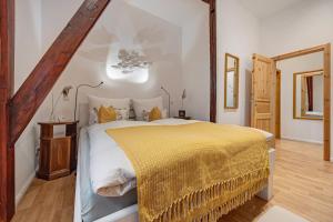 a bedroom with a large bed with a yellow blanket at Ferienwohnung Varga Schafstedt in Schafstedt