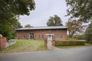 a large red brick house with a driveway at Ferienwohnung Varga Schafstedt in Schafstedt