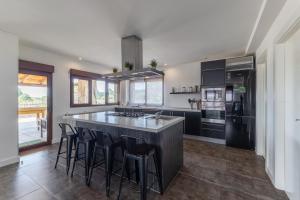 a kitchen with a large island with bar stools at Sierra Norte Madrid in El Berrueco
