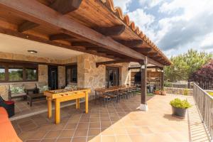 an outdoor patio with tables and a wooden pergola at Sierra Norte Madrid in El Berrueco