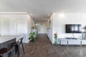 a kitchen and living room with white walls and a table at Sierra Norte Madrid in El Berrueco