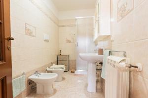 a bathroom with a toilet and a sink at Colombo Rooms in Sestu +16 photos