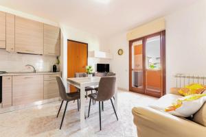 a kitchen and living room with a table and chairs at Colombo Rooms in Sestu