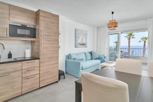 a kitchen and living room with a blue couch at Brisa Marina in Almuñécar