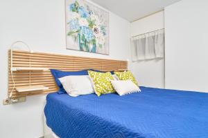a bedroom with a blue bed with pillows at Brisa Marina in Almuñécar +23 photos
