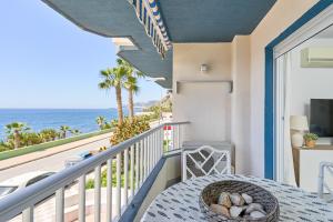 a balcony with a table and a view of the ocean at Brisa Marina in Almuñécar