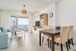 a dining room and living room with a table and chairs at Brisa Marina in Almuñécar
