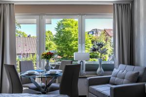 a living room with a table and chairs and a large window at Ferienwohnung mit Badestrand in Glücksburg