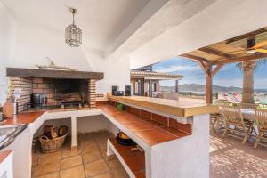 an open kitchen with a fireplace and a view of the ocean at Finca La Haima in Motril