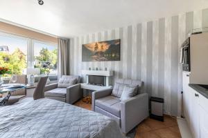 a bedroom with a bed and chairs and a fireplace at Ferienwohnung mit Badestrand in Glücksburg