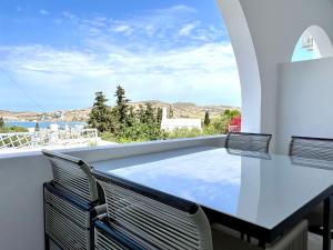a view from the balcony of a house with a table and chairs at aeolian blu 5 in Parikia