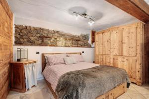 a bedroom with a bed and a stone wall at La Maison de Karen The Deer House in Gignod