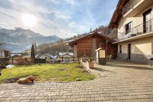 a dog laying on the ground next to a building at La Maison de Karen The Deer House in Gignod