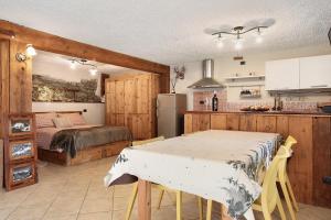 a kitchen and dining room with a table and a bed at La Maison de Karen The Deer House in Gignod