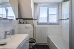 a bathroom with a sink and a toilet and a tub at Ferienwohnung Schürer in Meckenbeuren +20 photos