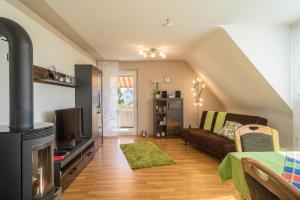 a living room with a couch and a tv at Ferienwohnung Schürer in Meckenbeuren