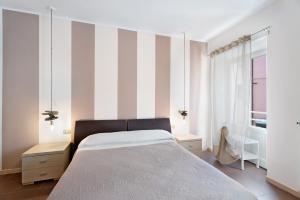a bedroom with a bed and a striped wall at Vecchia Scala in Germignaga