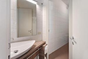 a white bathroom with a sink and a mirror at Vecchia Scala in Germignaga +19 photos