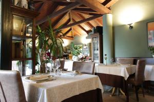 ein Restaurant mit zwei Tischen mit weißen Tischdecken in der Unterkunft Il Giardinetto in Vercelli