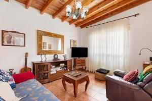 a living room with a couch and a tv at Rosa del Negro in Alojera