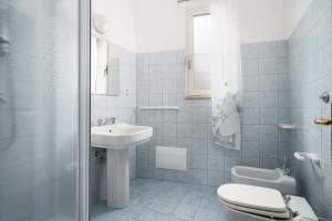 a white bathroom with a sink and a toilet at Casa Picchereddu in Orosei