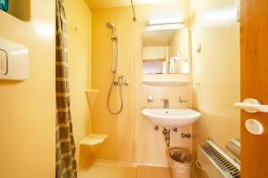 a small bathroom with a sink and a shower at Ferienwohnung Jonagold Schnalserhof in Laces +8 photos