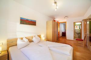 a bedroom with a large white bed with white pillows at Ferienwohnung Jonagold Schnalserhof in Laces
