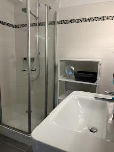 a white bathroom with a shower and a sink at Ferienwohnung deluxe in Goslar +10 photos