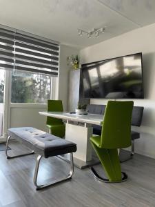 a kitchen with a table and two green chairs at Ferienwohnung deluxe in Goslar