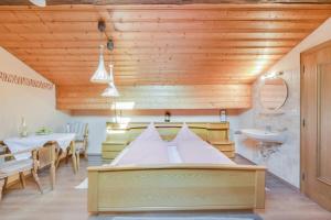a room with a bed and a table and a sink at Beim Kreuzfelder Zwiesel in Inzell