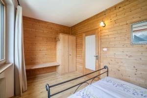 a bedroom with wooden walls and a bed in a room at Langstein Wohnung Lavendel in Coldrano