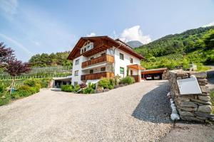 a house on a gravel road in front of a mountain at Langstein Wohnung Lavendel in Coldrano