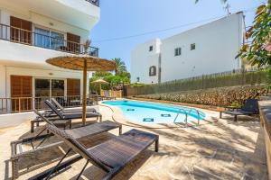 a swimming pool with chairs and an umbrella at Gran Sol Family 2 in Felanitx