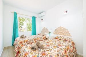 two beds in a bedroom with blue curtains at Gran Sol Family 2 in Felanitx
