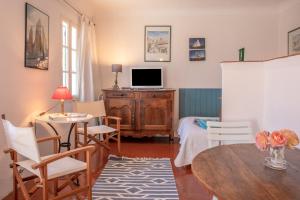 a living room with a table and a tv at Studio Le Val de Pons Ramatuelle in Ramatuelle