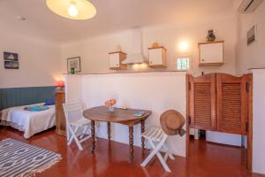 a room with a table and chairs and a bed at Studio Le Val de Pons Ramatuelle in Ramatuelle