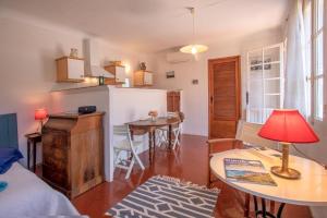 a kitchen and living room with a table and a refrigerator at Studio Le Val de Pons Ramatuelle in Ramatuelle +27 photos