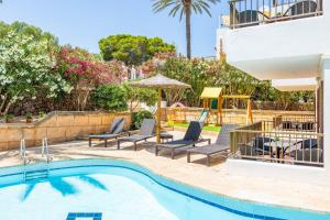 a swimming pool with chairs and an umbrella at Gran Sol Family 2 in Felanitx
