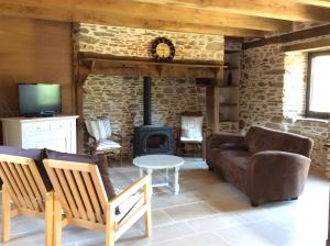 a living room with a fireplace and a couch and a stove at La Maison Leontine in Cahus