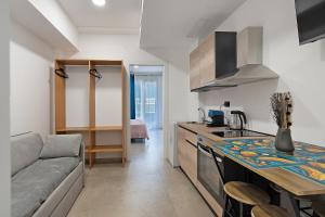 a kitchen and living room with a couch and a table at I Tramonti Del Golfo - Kennedy in Balestrate