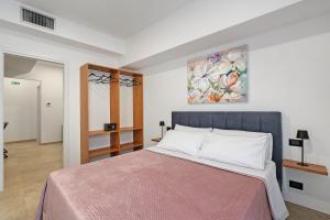 a bedroom with a bed and a painting on the wall at I Tramonti Del Golfo - Kennedy in Balestrate