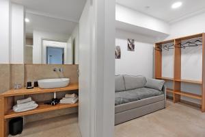 a bathroom with a couch and a sink at I Tramonti Del Golfo - Kennedy in Balestrate +122 photos
