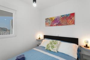 a bedroom with a bed and a painting on the wall at vv Luca vista mar in Puerto Rico de Gran Canaria +20 photos