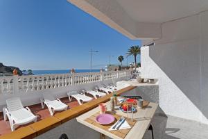 a balcony with a table and chairs and the beach at vv Luca vista mar in Puerto Rico de Gran Canaria