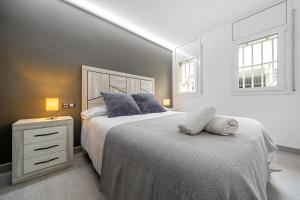 a bedroom with a large bed and a nightstand and two windows at Kaixo in Calafell