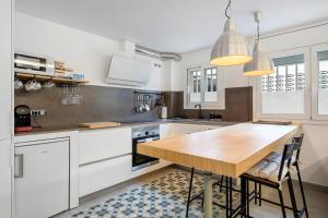 a kitchen with white cabinets and a wooden table at Kaixo in Calafell