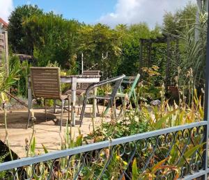 a patio with a table and chairs in a garden at Chez Chriss in Bourges