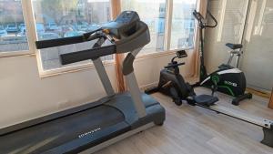 a gym with a treadmill and two exercise bikes at Chez Chriss in Bourges +18 photos