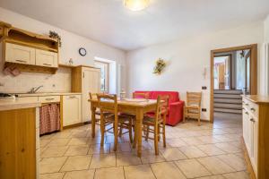 a kitchen and dining room with a table and chairs at Agritur piazera con terrazzo in Ronzo Chienis